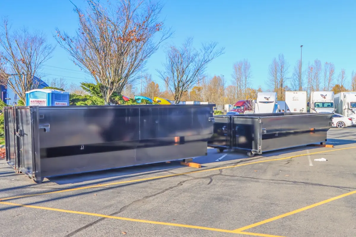 Professional dumpster rental service with roll-off container on residential driveway in East Hills